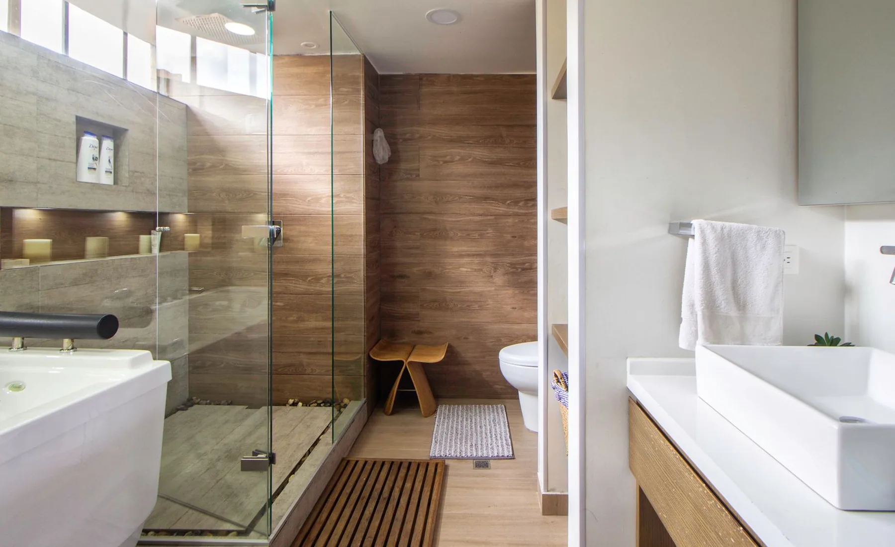 Modernes Bad mit bodengleicher Glasdusche und Holzwand