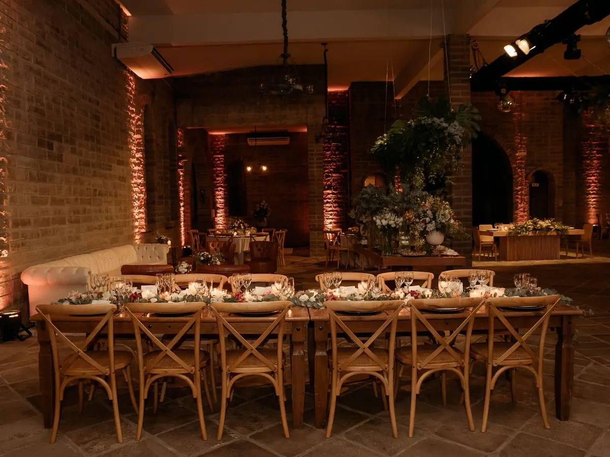 Lange Tafeln mit Lichterketten für das Hochzeitsdinner in der Scheune