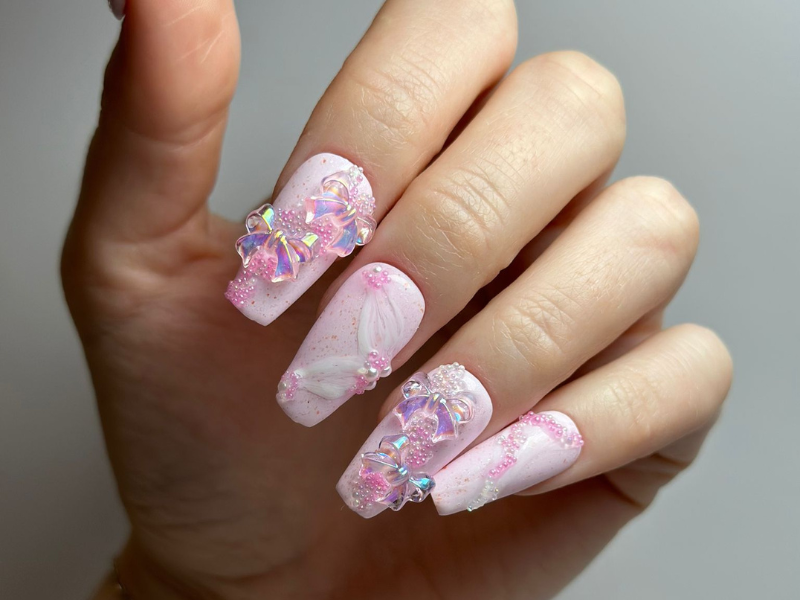 Pinkes Nageldesign mit Blüten und Glitzer